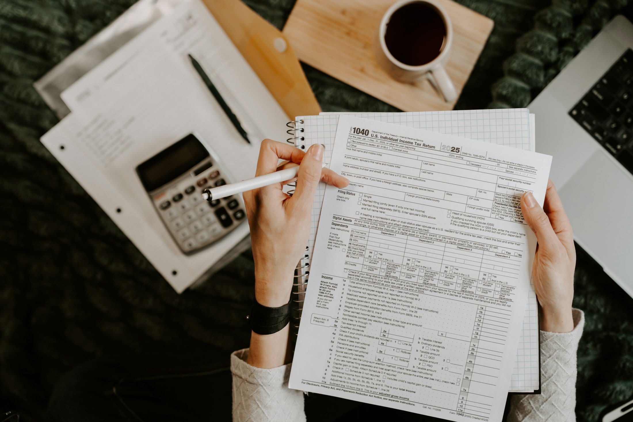 A preparer holding a tax return at a desk
